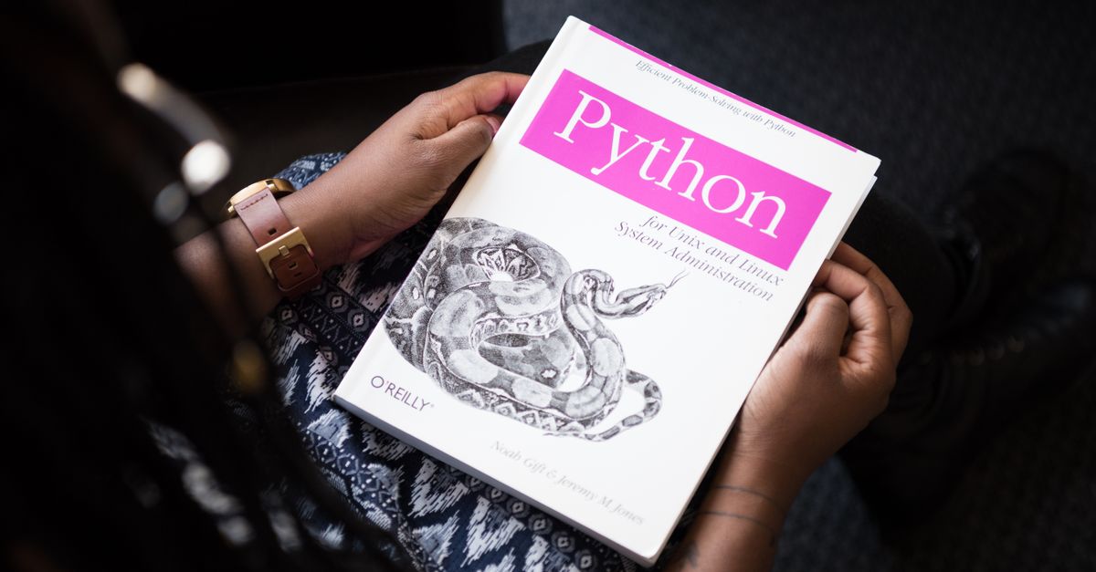 A person reads 'Python for Unix and Linux System Administration' indoors.